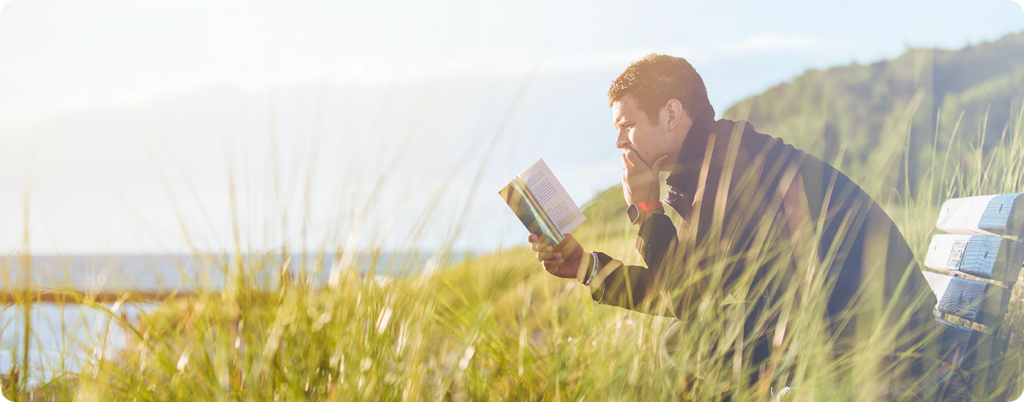 Man reading a book in nature. 
