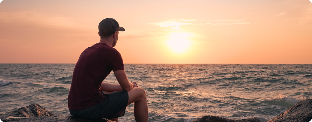 Man at the beach watching the sunset. 