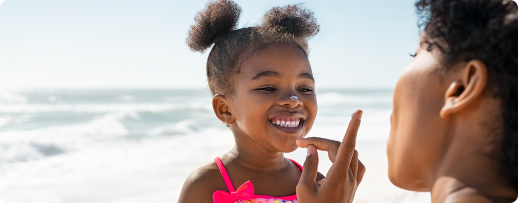 A little girl using sunscreen 