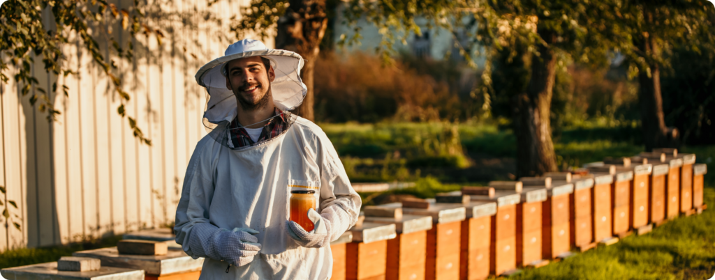 A beekeeper with a jar of honey