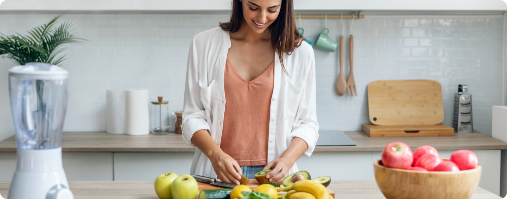 A woman cutting fruit in the kitchen