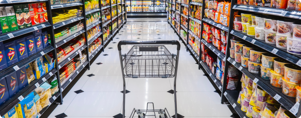 A shopping cart in an aisle of highly processed foods