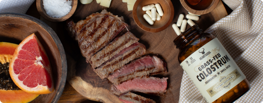 A bottle of grass fed colostrum next to a steak