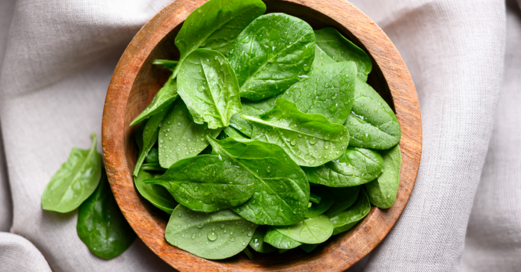 A bowl of spinach on the table