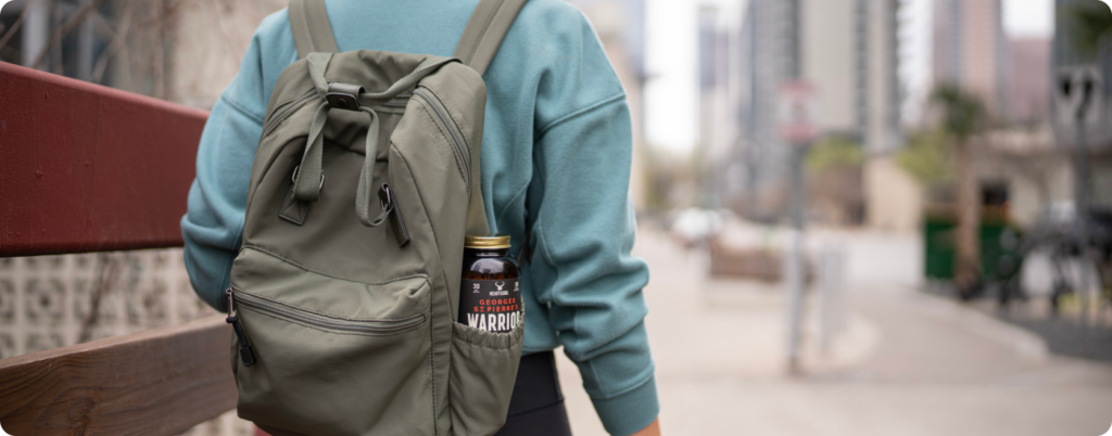 A woman traveling with a bottle of Heart & Soil supplements