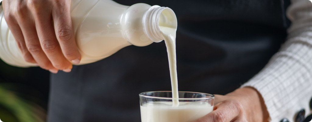 Someone pouring kefir into a glass