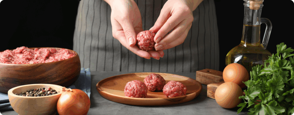 A person preparing beef heart meatballs