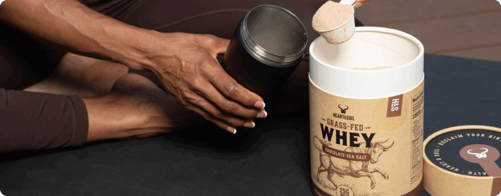 A woman scooping grass-fed whey protein powder