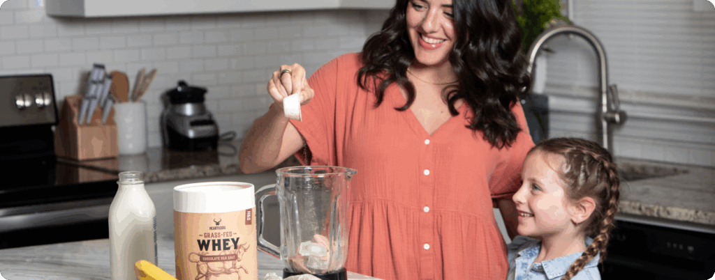 A mother and daughter making a protein shake